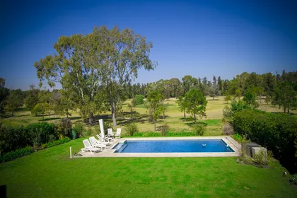 Piscina moderna en entorno rural con deck y césped — proyecto Arquitectura, por Geo Estudio, en Buenos Aires