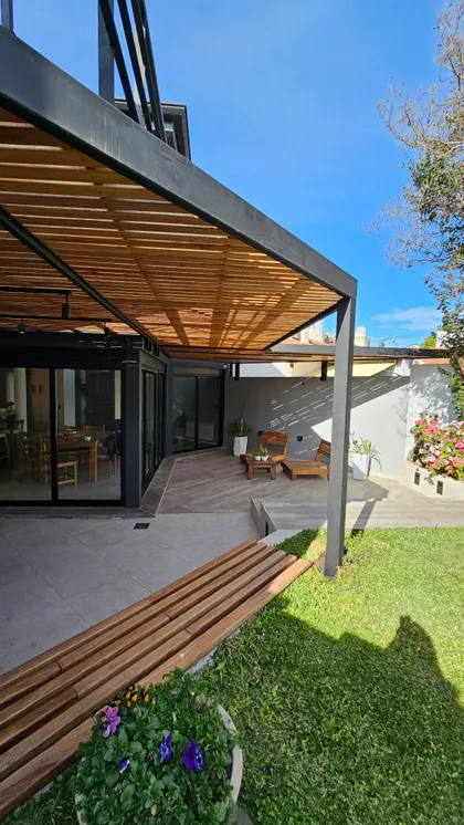 Patio moderno con pergola de madera, deck y jardin verde luminoso — proyecto Timeless House, por Estudio UFV72, en B1602 Florida