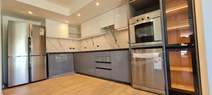 Cocina moderna con electrodomésticos integrados y gabinetes blancos y grises — proyecto Casa, por R-mod amoblamientos, en La Plata