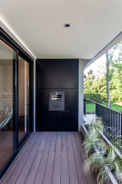 Terraza moderna con deck de madera y parrilla incorporada — proyecto Alvear AV, por V2 Arquitectos, en City Bell