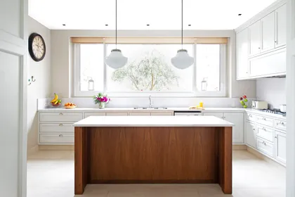 Cocina moderna con isla de madera oscura y gran ventana — proyecto Casa MF, por Estudio Junor, en Belén de Escobar