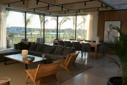 Living comedor moderno con grandes ventanales y detalles en madera — proyecto Casa Pomelo, por FeelX Tecnología SRL, en Canning