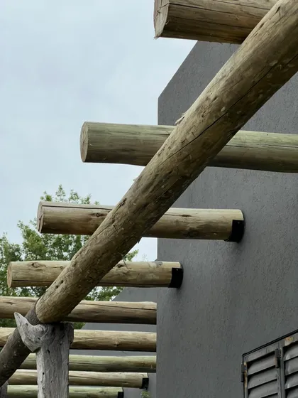 pérgola moderna de troncos y fachada texturada — proyecto CASA RZ, por SEDE Arq., en Pilar