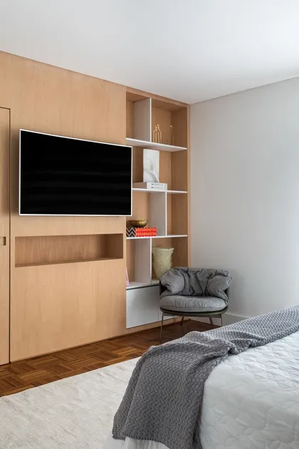 Dormitorio moderno con panel de madera integrado y televisor empotrado — proyecto Apartamento BP, por GabrielaCasagrande Arquitetura