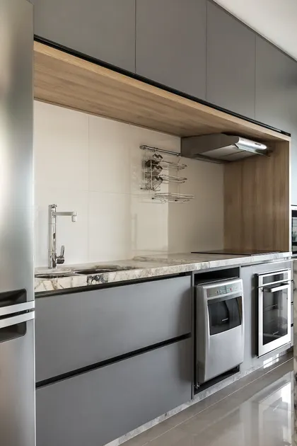 Cocina moderna con mesada de mármol, muebles grises y madera natural — proyecto Apartamento MV, por GabrielaCasagrande Arquitetura