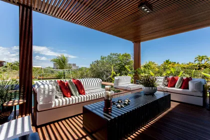 Terraza moderna con pergola de madera, sofás tapizados y vista al horizonte — proyecto Residência MQ, por Milcent Arquitetura