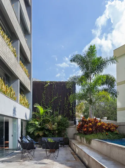 Patio contemporáneo con jardín vertical, pileta y plantas tropicales — proyecto APARTAMENTO FL, por Frederico Bicalho Arquitetura