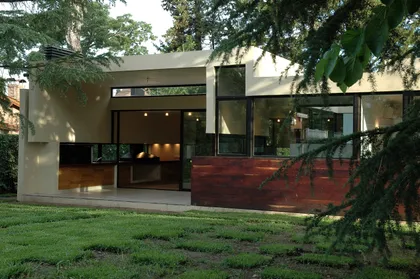 Casa moderna con fachada hormigón, grandes ventanales y deck de madera — proyecto Casa en Pilar, por Luciano Kruk, en Pilar