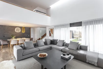 Living comedor moderno con doble altura y ventanales amplios — proyecto Nordelta, por Judith Babour, en Nordelta