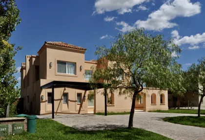 Casa moderna beige con ventanales y pérgola de madera — proyecto Santa Catalina, Villanueva, por Marconi Silva Arquitectos, en Benavidez