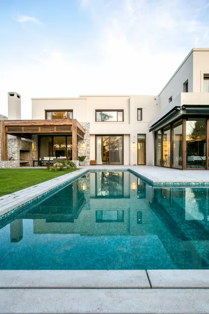 Casa moderna con pileta espejo, deck y jardín impecable — proyecto PGC-01, por VGLA Arquitectos, en General Pacheco