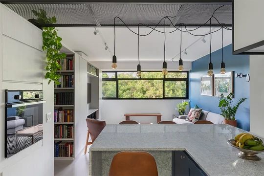 Comedor moderno con isla central, ventanal y plantas colgantes — proyecto Apartamento 415N, por Coda Arquitetos