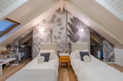 Dormitorio abuhardillado con papel mural botánico y vigas — proyecto Proyecto Altillo, por efe arquitectura, en Ciudad de Córdoba