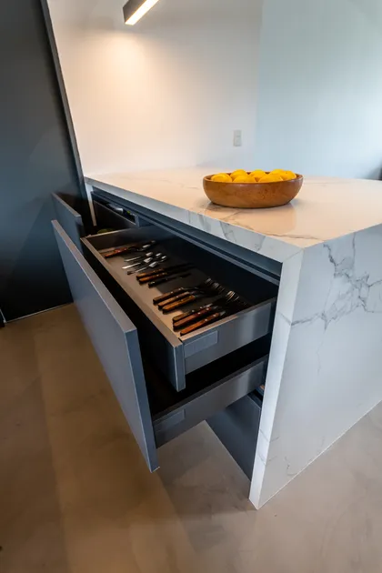 Cocina moderna con isla, cajón abierto y frutero con limones — proyecto Santa Isabel - Andrea Gonzalez, por ABEJA CONCEPT, en Nordelta