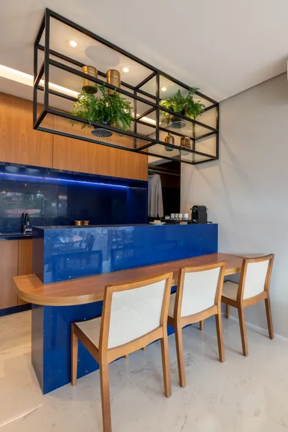 Cocina moderna con isla azul, mesada curva madera y estantería industrial — proyecto Brick 1, por Pricila Dalzochio