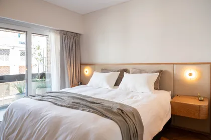 Dormitorio moderno con cama king, cortinas grises y luz cálida — proyecto ALVEAR TYM, por AB ARQUITECTURA, en Recoleta