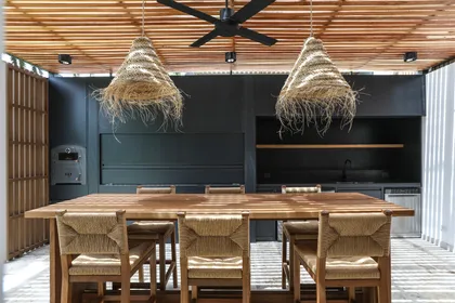 Comedor exterior con techo de madera y lámparas de paja — proyecto Obra La Posta, por Arq. Lourdes Yarade Saravia, en Pilar