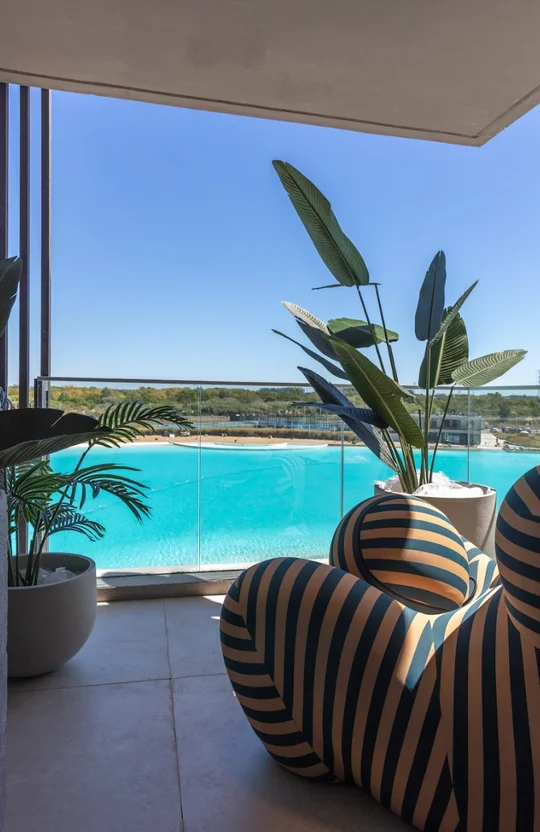 Balcón moderno con vista a piscina turquesa y muebles a rayas — proyecto Loly Albasini, por San Lorenzo Design, en Cam. de los Remeros 1585