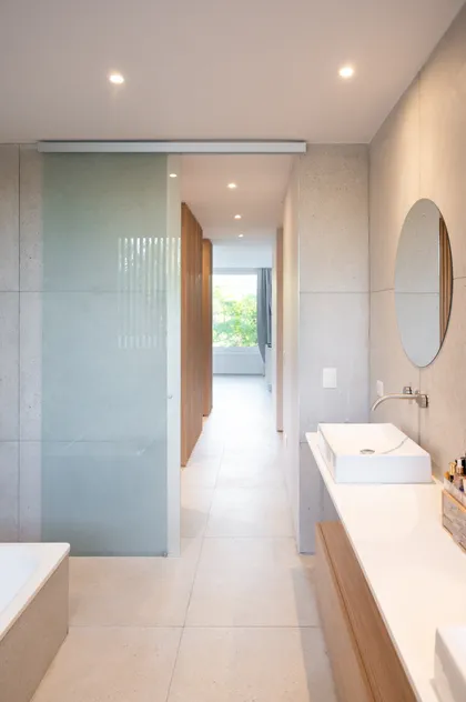 Baño moderno con vanitory flotante de madera y lavabo rectangular — proyecto Campo grande I, por Juarez-Fevre Estudio de Arquitectura , en Pilar