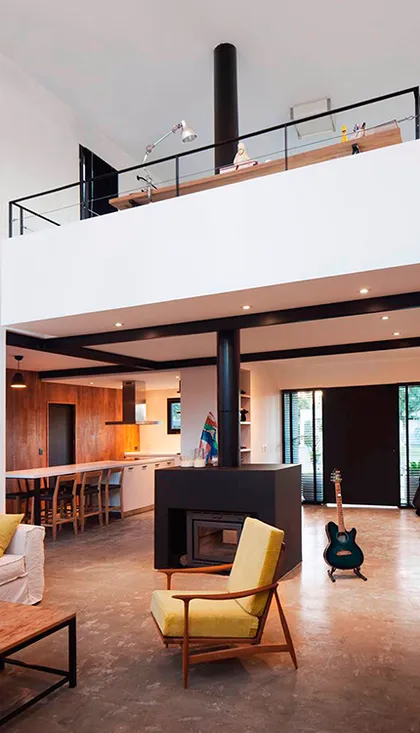 Living moderno industrial con doble altura, chimenea y sillón amarillo — proyecto Casa coco, por Estudio PK, en B1648 Tigre