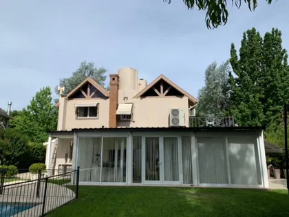 Fachada de casa moderna con grandes ventanales y vegetación exuberante — proyecto Reforma V, por de Sautu Di Matteo arquitectos , en Canning
