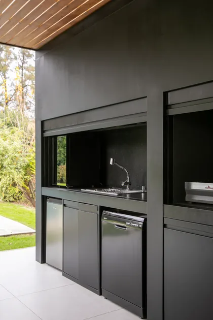 Cocina exterior moderna gris oscura con techo de madera — proyecto Obra Newman J, por Arq. Lourdes Yarade Saravia, en Benavidez