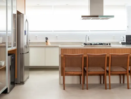 Cocina moderna con isla central, sillas de madera y mesada clara — proyecto Apartamento Debski, por Felipe Lopes