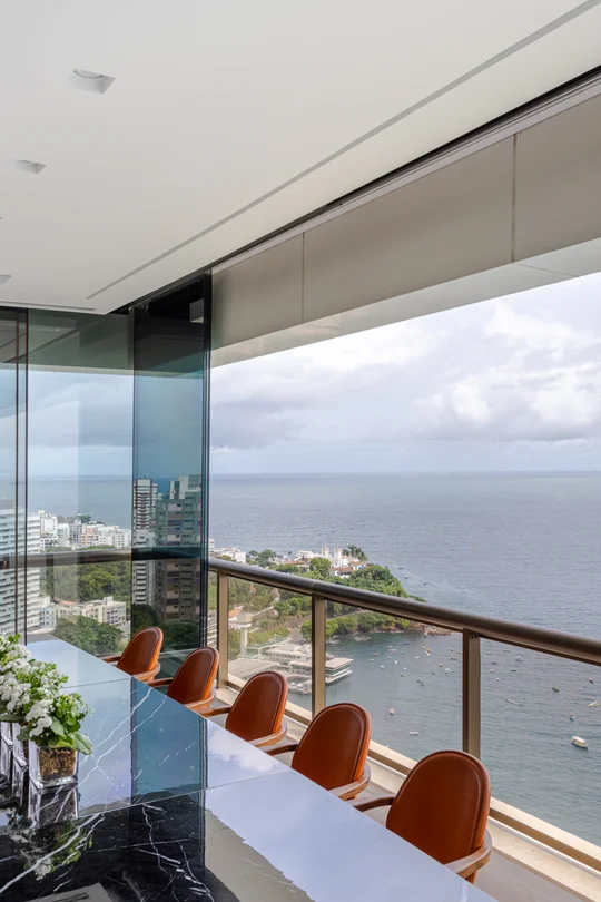 Balcón moderno con vista panorámica al mar y sillas tapizadas — proyecto Apto S | A, por Arquitetura Paulo Melo E Paulo