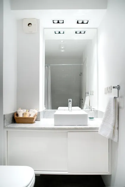 Baño moderno con bacha cuadrada, espejo grande y muebles blancos — proyecto República de la India, por Estudio Basa, en Palermo