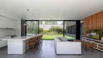 Cocina y living modernos con ventanales al jardín — proyecto Casa LP0405 - Nómade Arquitectura, por Ramiro Sosa Fotografia