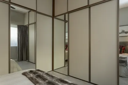 Dormitorio moderno con vestidor integrado y paneles de madera — proyecto Obra Recoleta, por M. Beatriz Gonzalez Zuelgaray, en Recoleta