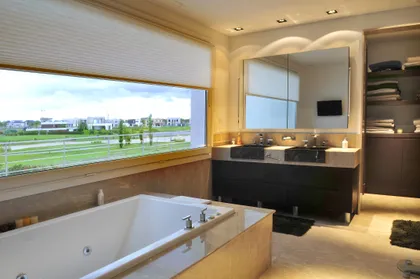 baño moderno con bañera exenta y vista al exterior — proyecto Neoclásica, por Oppel Arquitectura