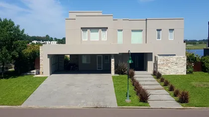 Fachada moderna de casa suburbana con detalles de piedra y hormigón — proyecto LRCC 488, por LESSI ARQUITECTURA, en Los Cardales