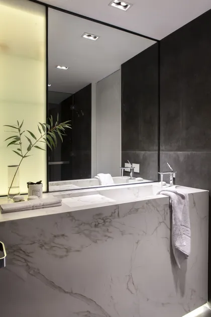 baño moderno con mármol, iluminación indirecta y grifería minimalista — proyecto Beruti I, por Karen Garber Arquitecta, en Palermo
