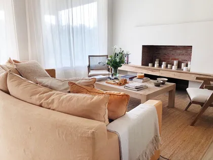 Sala de estar moderna y luminosa con chimenea y sofá grande — proyecto CASTAÑOS, NORDELTA , por Greschek Obras , en Nordelta
