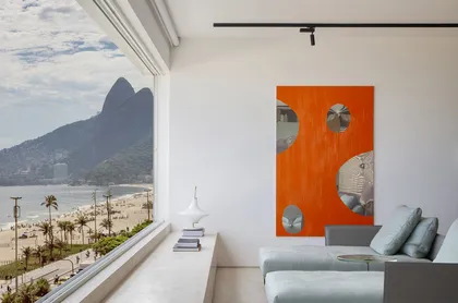 Balcón moderno con vista a la bahía, sofá gris y arte naranja — proyecto PS House, por Studio Ro-ca