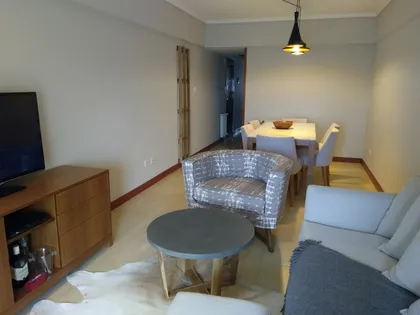 Living y comedor moderno con detalles en madera y tonos grises — proyecto Departamento RA, por Vicky Hurrell, en Mar del Plata