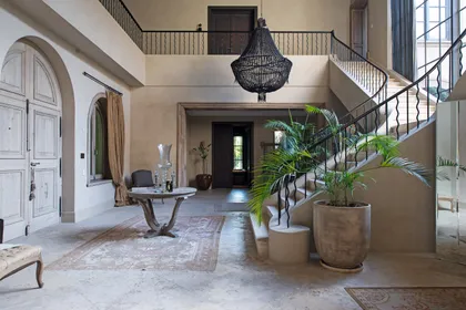 Hall de doble altura con escalera hierro, plantas y luz natural — proyecto Casa Toscana , por Estudio Du