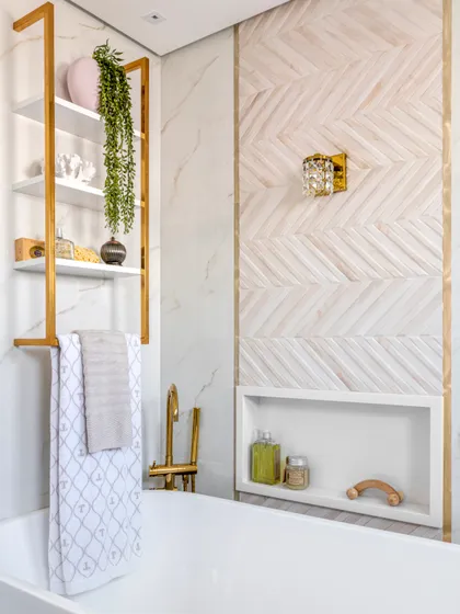Baño moderno con bañera exenta, paredes de mármol y madera, detalles dorados — proyecto PANAMBY, por OKA ARQUITETURA, en São Paulo