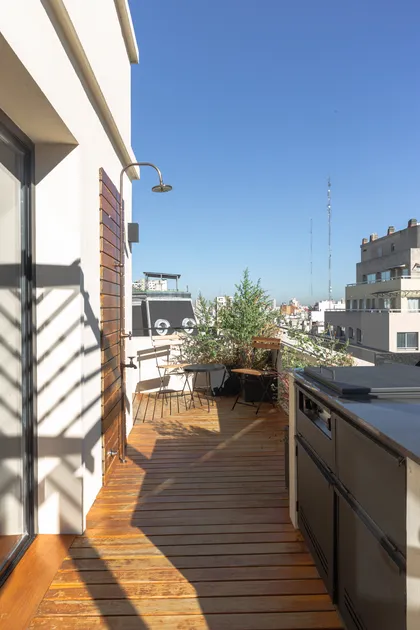 Terraza moderna con deck de madera, plantas y ducha exterior — proyecto Viamonte II, por WA arquitectura, en CABA