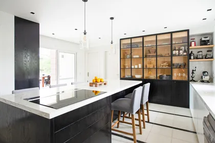 Cocina moderna con isla de madera oscura y mármol blanco — proyecto Santa Maria De Tigre, por Parq Estudio, en Tigre