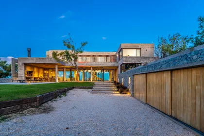 Casa moderna con hormigón y madera, ventanales y pérgola — proyecto CASA sobre el MAR, por Guerrero Arquitectos, en Pinamar