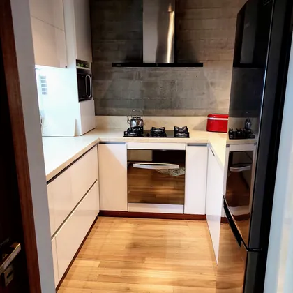 Cocina moderna con gabinetes blancos y pared de piedra — proyecto Cocina pequeña, por Tu Mueble, muebles a medida, en Gonnet