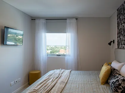 Dormitorio moderno con mucha luz natural y cortinas blancas — proyecto Alto Panorama, por Interiores a la carta, en Córdoba