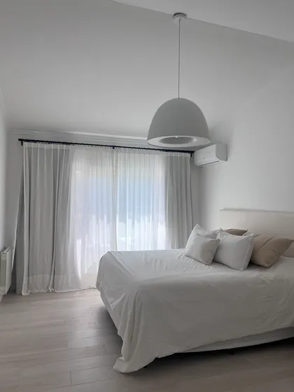 Dormitorio moderno con luz colgante y cortinas blancas — proyecto CASA LA LOMADA , por Estudio Grupo 32, en Pilar