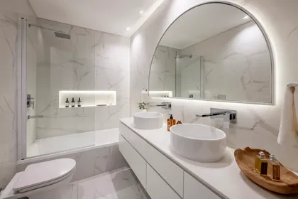 Baño moderno con bañera exenta, espejo curvo y mármol — proyecto AS, por Estudio Basa, en Buenos Aires