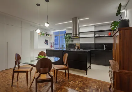 Cocina y comedor modernos de planta abierta, isla negra y mesa de vidrio — proyecto Apartamento Praça Cairo, por Balsa Arquitetura