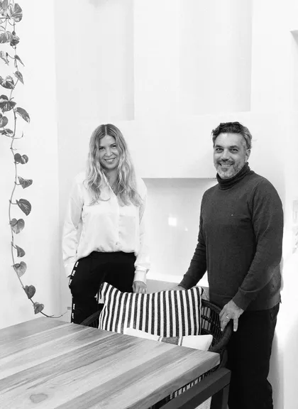 Pareja sonriente en sala comedor moderna con mesa de madera y planta colgante — proyecto Proyecto Gaby P. , por LINEA NETA diseño interior , en Canning