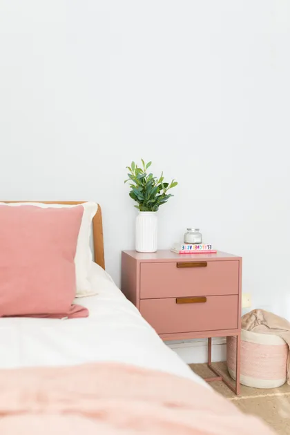 Habitación con cama, mesita de noche rosa y planta — proyecto Línea Queens, por ALTORANCHO, en San Isidro