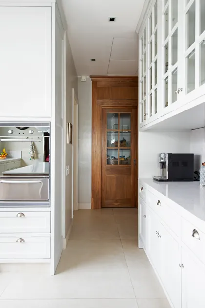Cocina moderna con puerta de madera y alacenas blancas — proyecto Casa MF, por Estudio Junor, en Belén de Escobar